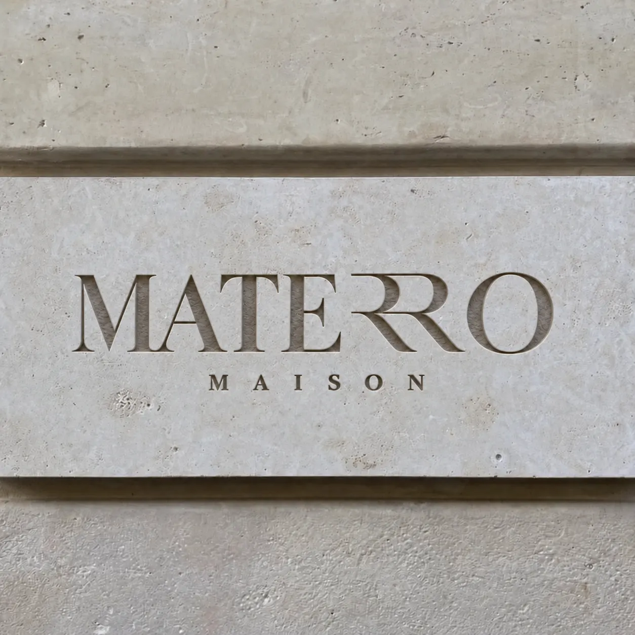 Logo MATERRO Maison vytesané do travertinové stěny